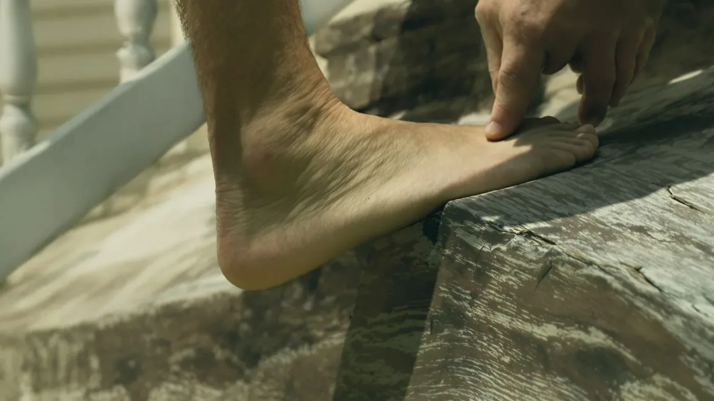 Bare feet stepping up worn wooden stairs showing body awareness after a week of practice
