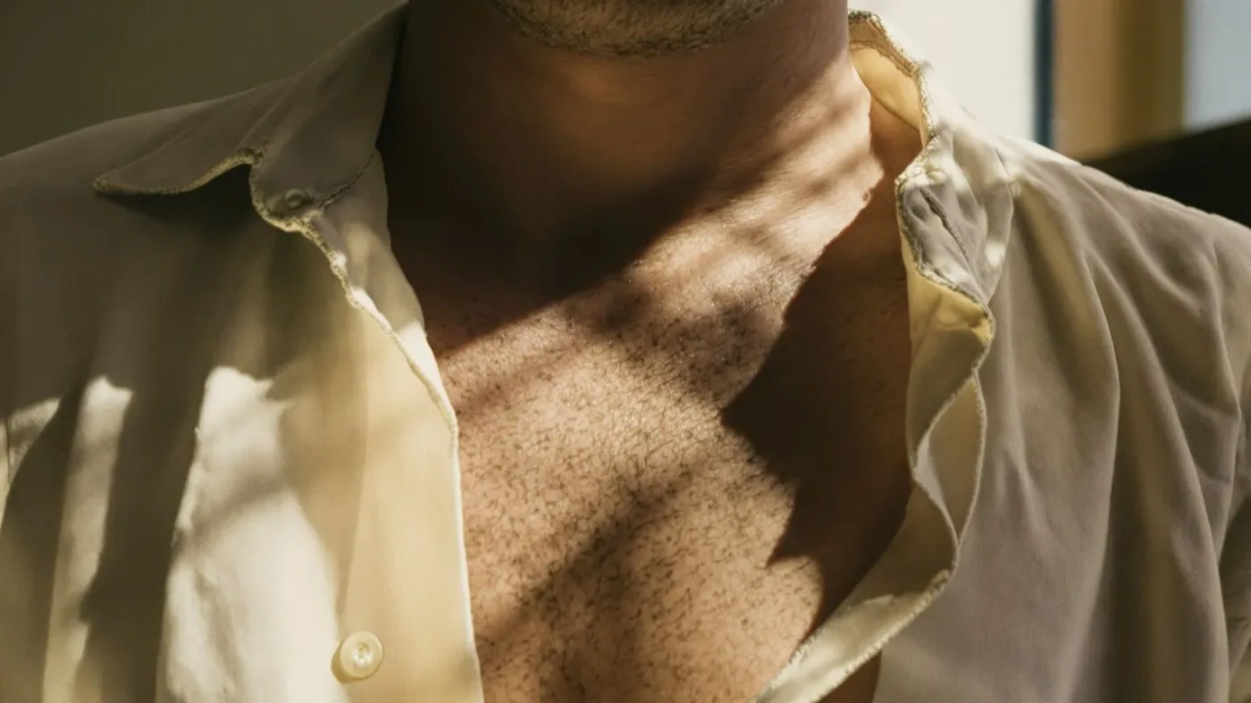Close-up of chest and breath softening after practicing being real showing physical relief in warm light