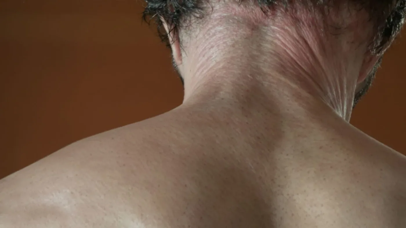 Close-up of man's tense neck and clenched jaw showing emotional suppression effects held in the body