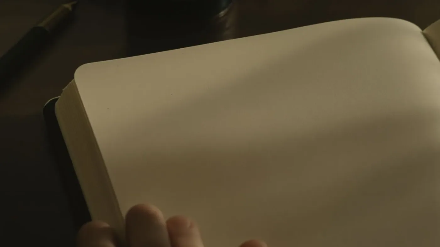 Fingertips resting gently on open journal page with pen laid down, the real question beneath feeling misunderstood