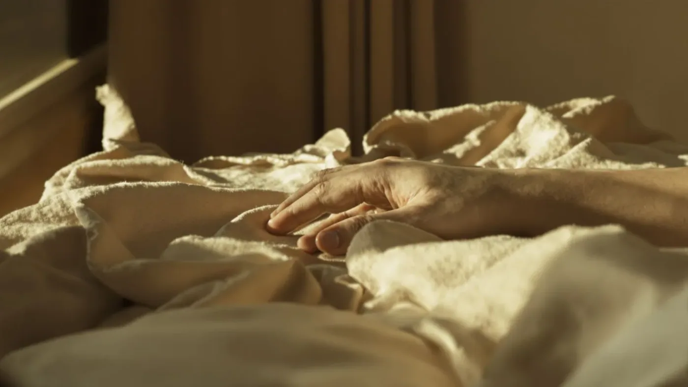 Hand resting palm-down on linen blanket in warm light showing one immediate step for the moment self-hate hits