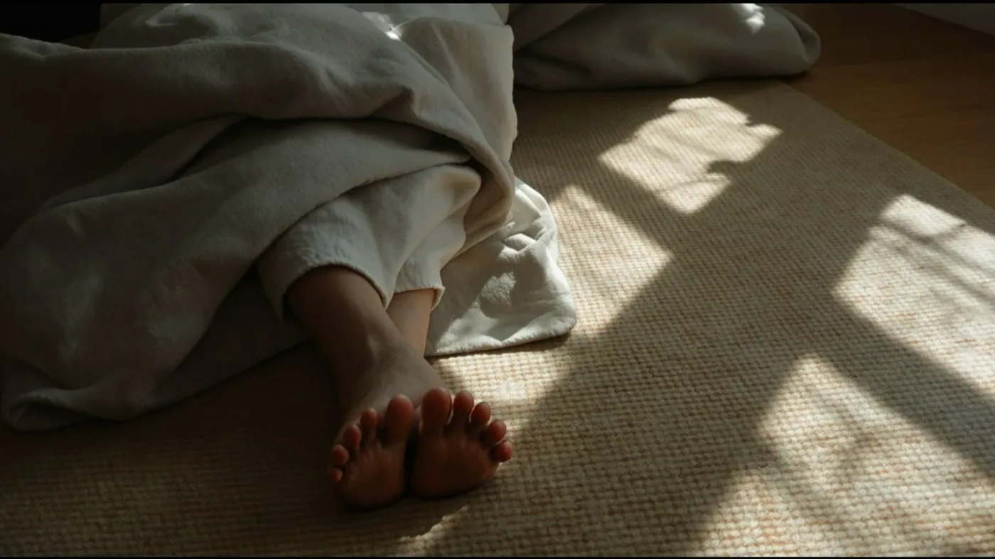 Person lying on floor with palms down practicing a safe somatic exercise to release trauma at home